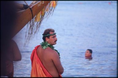 Bow of boat and man in traditional dress.