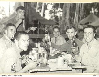 MALMAL MISSION, JACQUINOT BAY, NEW BRITAIN. 1944-11-24. TROOPS OF B COMPANY, 594TH ENGINEER BOAT AND SHORE REGIMENT, UNITED STATES ARMY ATTACHED TO THE 5TH AUSTRALIAN DIVISION ENJOYING THEIR ROAST ..