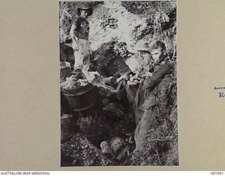 WEWAK POINT, NEW GUINEA, 1945-05-11. MEMBERS OF 2/4 INFANTRY BATTALION PULLING A DEAD JAPANESE OUT OF A CAVE