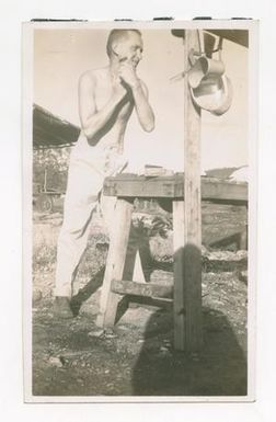 [Photograph of Man Shaving Outside]