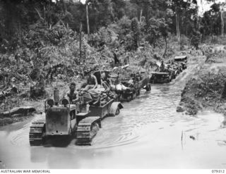 A jeep train carrying the gear of personnel of the 9th Infantry Battalion who are being withdrawn from Mosigetta to Motupena Point for a fortnight's rest, negotiating a section of the road which ..