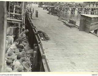 FINSCHHAFEN, NEW GUINEA. 1945-04-04. HEADQUARTERS 26 INFANTRY BRIGADE TROOPS LINE THE RAILS OF THE VAN HEUTSZ AS THE VESSEL BERTHS