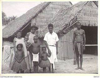 GARARA, NEW GUINEA, 1945-06-28. FATHER L. RAURELA, AN ORDAINED ANGLICAN PRIEST, WITH HIS WIFE AND CHILDREN, WITH THEM STANDS A NATIVE TEACHER FROM THE SOLOMON ISLANDS WHO HAS LIVED IN GARARA FOR 35 ..