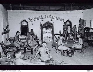 PORT MORESBY, PAPUA, 1942-07-20. AN EVACUATED MISSION CHAPEL CONVERTED TO BILLETS FOR AUSTRALIAN TROOPS. THE INSCRIPTION OVER THE DOOR IS THE PAPUAN TRANSLATION OF THE TEXT "GOD BE WITH YOU"