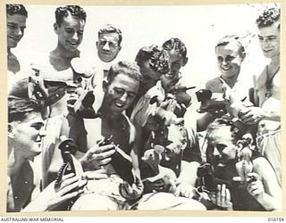 NEW GUINEA. 1943-11-19. INFORMAL GROUP PORTRAIT OF BOMBARDIER R.G. DOCKERY OF WOLLONGONG, NSW, PRIVATE (PTE) D.W.V. ALLEN OF BRISBANE, PTE G.A. KNELL OF ROCKHAMPTON, GUNNERS A. DAVIS OF WOOLLAHRA, ..