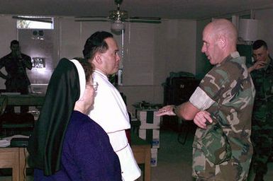 Colonel Frank W. Hicks, Commanding Officer, Marine Forces, Operation PACIFIC HAVEN, greets Archbishop Anthony Sablan Apuron, the Arch-Bishop of Guam, at Tiyan, Guam. The Arch-Bishop was at Tiyan to perform New Years day Mass for the Marines and Kurdish refugees during PACIFIC HAVEN. PACIFIC HAVEN provided Kurdish evacuees political asylum from Iraq. While on Guam, the Kurds are provided shelter, food, clothing, medical care and assimilation classes for life in the United States