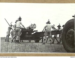 LYTTON, QLD. 1943-11-11. GUN DRILL AT T AUSTRALIAN HEAVY BATTERY, 155MM. EQUIPMENT. PERSONNEL ARE TRAINED HERE TO TAKE OVER FORTRESS AREAS IN NEW GUINEA. SHOWN ARE: SERGEANT H. W. JEFFREY (1); ..