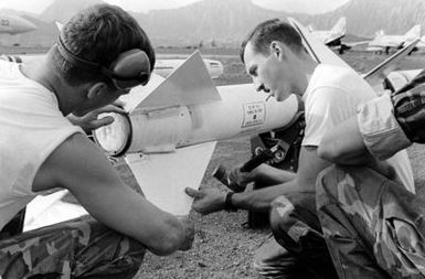 Personnel from Marine Fighter Attack Squadron 235 (VMFA-235) do a final check of the fins on an AIM-7 Sparrow III missile before loading it aboard an F-4 Phantom II aircraft
