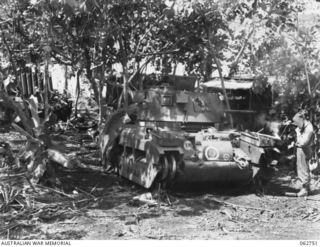 PERSONNEL OF THE 1ST TANK BATTALION GROUP WORKSHOPS, AUSTRALIAN ELECTRICAL AND MECHANICAL ENGINEERS, REPAIRING A TANK WHICH HAS JUST COME OUT OF THE FRONT LINES