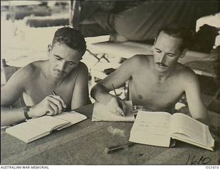 TADJI NEAR AITAPE, NORTH EAST NEW GUINEA. C. 1944-10. TWO MEMBERS OF NO. 100 (BEAUFORT) SQUADRON RAAF SITTING AT A TABLE IN A TENT WITH PEN TO PAPER AND BOOKS