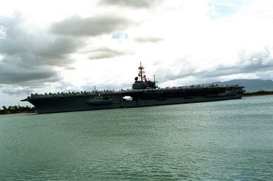 With its crew manning the rails, the aircraft carrier USS RANGER (CV-61) heads out to sea following a visit to the naval station. The RANGER is en route to its home port of Naval Air Station, North Island, Calif., after serving in the Persian Gulf region during Operation Desert Shield and Operation Desert Storm.