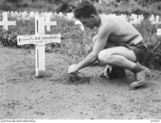 KOKODA, NEW GUINEA. 1944-04-11. VX125001 SIGNALMAN R. WILLIAMS, 18TH LINES OF COMMUNICATION SIGNALS TENDING THE GRAVE OF THE LATE PRIVATE BRUCE STEEL KINGSBURY VC, 2/14TH INFANTRY BATTALION, AT THE ..