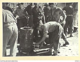 MILILAT, NEW GUINEA. 1944-06-19. TROOPS OF THE AUSTRALIAN ARMY SERVICE CORPS AND HEADQUARTERS, 5TH DIVISION HELPING THEMSELVES TO A CUP OF TEA AT THE SALVATION ARMY RED SHIELD HUT. IDENTIFIED ..