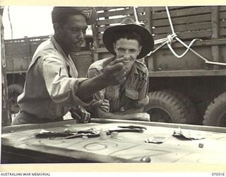 WARD'S DROME, PORT MORESBY, PAPUA, 1944-02. SERGEANT GEORGE S. HARRIS, OF TOLEDO, OHIO, AN AMERICAN SERVICEMAN, (1), SHOWING SERGEANT HAROLD MCGUINNES, (2), THE FINER POINTS OF "CRAPS", ONE OF THE ..