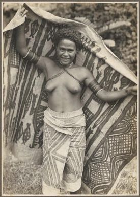 Girls from Village Wanigella [Wanigela], North Coast [girl holding a decorated cloth behind her] Frank Hurley