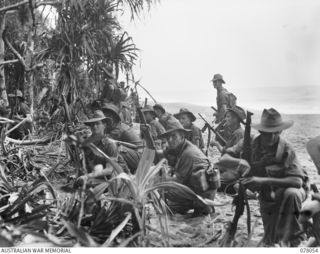 A PLATOON OF C COMPANY, 2/11TH INFANTRY BATTALION, RESTING ON THE RIVER BANK BEFORE THE ATTACK ON JAPANESE POSITIONS ON A HILL BEYOND MATAPAU