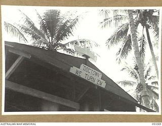 MILNE BAY, NEW GUINEA. 1943-07-01. SHIP AND SIGN (WE TURN 'EM) ON THE HEADQUARTERS OF "C" GROUP, 2/3RD AUSTRALIAN DOCKS OPERATING COMPANY, ROYAL AUSTRALIAN ENGINEERS