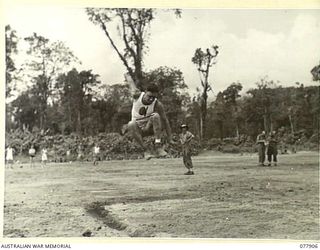 TOROKINA, BOUGAINVILLE ISLAND. 1945-01-01. PRIVATE N.F. FOX, 61ST INFANTRY BATTALION, COMPETING IN THE HOP, STEP AND JUMP EVENT AT THE ATHLETIC MEETING ORGANISED BY HEADQUARTERS, 3RD DIVISION