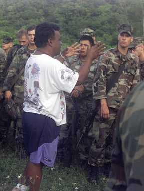 Marines from 3rd Battalion 7th Marines India Company, listen to a World War II battlefield sites tour guide on Peleliu after a simulated airfield seizure during Exercise KOA THUNDER 2001. KOA THUNDER is an exercise involving elements of 1ST Marine Air Wing (MAW), and 3rd Marine Division, where Marines conduct an Operational Readiness Exercise (ORE). The Aviation Support Element (ASE) from Kaneohe Bay, Hawaii, will be tested on command and control of several different missions, to include Tactical Recovery of Aircraft and Personal (TRAP), airfield seizures, and a Noncombatant Evacuation Operation (NEO)