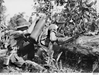 BOUGAINVILLE, SOLOMON ISLANDS. 1944-12-21. SAPPER I.G. MCCOULLOUGH, 55/53 INFANTRY BATTALION, (1), WITH SERGEANT J.T. BARRY, 25 INFANTRY BATTALION, (2) AT HEADQUARTERS 3 DIVISION AS THEY PREPARE ..