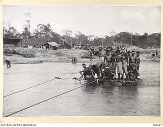 SOUTH BOUGAINVILLE. 1945-07-24. NATIVES RIDING ON A RAFT MADE FROM 44 GALLON DRUMS BY 6 MECHANICAL EQUIPMENT COMPANY, ROYAL AUSTRALIAN ENGINEERS. THE RAFT WAS USED TO FERRY STORES AND TROOPS ACROSS ..