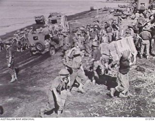 1943-09-15. LAE SALAMAUA ISOLATED. THROBBING ACTIVITY ON A BEACH NORTH WEST OF LAE WHERE AN HOUR EARLIER THERE WAS NO SIGN OF WAR. MEN, JEEPS AND TRUCKS ARE MOVING FORWARD IN THE TRAIL OF THE ..