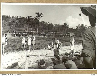 NEW GUINEA. 1943-11-20. TO CELEBRATE THE FOURTH ANNIVERSARY OF THE 18TH AUSTRALIAN INFANTRY BRIGADE A CHAMPIONSHIP SPORTS MEETING WAS HELD. IN THE FOREGROUND OF THIS PICTURE COMPETITORS IN THE 200 ..