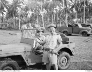 MILNE BAY, PAPUA. C. 1942-10. UNITED STATES OFFICER IN JEEP AND AIR COMMODORE W. H. GARING, RAAF, STANDING BESIDE JEEP AT THE GURNEY AIRSTRIP ON A SECTION COVERED WITH METAL AIRSTRIP MATTING