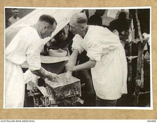 MELBOURNE, VICTORIA, AUSTRALIA. 1944-03-03. COPY OF A SCENE FROM A CINE STRIP OF TWO DOCTORS PREPARING THEMSELVES FOR AN OPERATION AT A FIELD DRESSING STATION SOMEWHERE IN NEW GUINEA