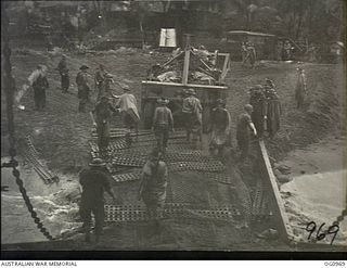 AITAPE AREA, NORTH EAST NEW GUINEA. C. 1944-04-22. RAAF PERSONNEL OF MOBILE WORKS, SURVEY AND SIGNALS UNITS PREPARE A TRACK TO ENABLE HEAVY EQUIPMENT TO BE BROUGHT ASHORE FROM A LANDING SHIP, TANK ..