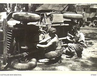 DALLMAN RIVER, NEW GUINEA, 1944-02-23. VX147400 CRAFTSMAN R.F. DUNCAN (1) AND VX109107 CORPORAL L.W. POWELL (2) MEMBERS OF THE 231ST LIGHT AID DETACHMENT ATTACHED TO THE 5TH DIVISION, REPAIR AND ..