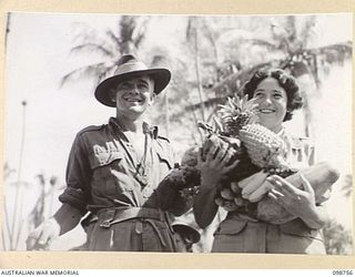 RABAUL, NEW BRITAIN. 1945-11-10. SERGEANT J. DAVIES, 18 ADVANCED ORDNANCE DEPOT (1) AND PRIVATE B. HOCKING, AUSTRALIAN ARMY MEDICAL WOMEN'S SERVICE, 118 GENERAL HOSPITAL (2) LOADED WITH FRUIT ..