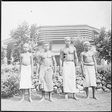 Four men of the Chinnery household staff standing in front of a stone wall, Malaguna Road, Rabaul, New Guinea, ca. 1936 / Sarah Chinnery