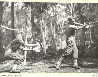 LAKONA, NEW GUINEA. 1944-04-05. QX28779 SERGEANT P.J. HORAN (1), WITH NX142221 PRIVATE W.T. DELOHERY (2), PLAYING A PRACTICE GAME OF SOFTBALL AT HEADQUARTERS 5TH DIVISION. THE GAME USING EQUIPMENT ..