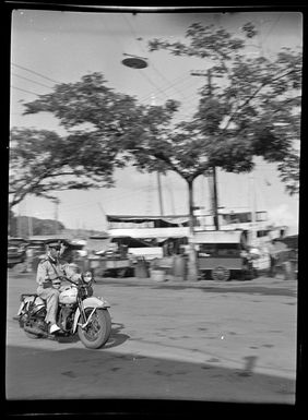 Street scene with police officer riding motor bike, Papeete, Tahiti