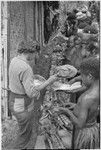 Nancy Cook distributes salt to men and children