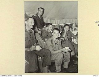 BOUGAINVILLE ISLAND. 1945-01-23. MEMBERS OF THE AUSTRALIAN ARMY NURSING SERVICE AND MEDICAL OFFICERS HAVING MORNING TEA IN THE SISTER'S MESS AT THE 109TH CASUALTY CLEARING STATION. IDENTIFIED ..