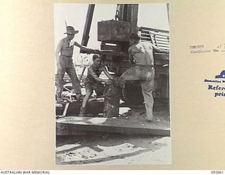 MINGA CREEK, WEWAK AREA, NEW GUINEA. 1945-05-30. SAPPERS OF 2/8 FIELD COMPANY ROYAL AUSTRALIAN ENGINEERS, USING A PORTABLE PILE DRIVER DURING BRIDGE BUILDING CONSTRUCTION. THIS PILE, SEVEN FEET ..