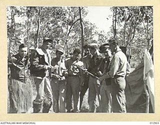 1942-07-17. U.S. ARMY AIR FORCE PERSONNEL EXAMINE TROPHIES OF THEIR STAY IN NEW GUINEA. LEFT TO RIGHT: 2ND LIEUT. STEPHEN A. STARR OF GOLDSBORO, NORTH CAROLINA; STAFF SGT JACK ROBERTS OF KINGSTON, ..