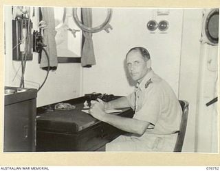 LANGEMAK BAY, NEW GUINEA. 1944-10-26. LIEUTENANT N.K. WALLIS, RAN, COMMANDER IN HIS CABIN ABOARD THE CORVETTE, GYMPIE
