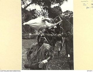 The aeroplane headdress worn during the 'Sing-sing' held by the natives in the Australian New Guinea Administrative Unit compound near the Song River, to celebrate the reoccupation of the area