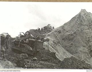 RAMU VALLEY, NEW GUINEA. 1943-12-19. AN AUSTRALIAN ARMY BULLDOZER AT WORK ON THE NEW ROAD TO THE 21ST AUSTRALIAN INFANTRY BRIGADE AREA