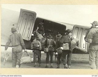 DUMPU, RAMU VALLEY, NEW GUINEA, 1944-03-21. VX16692 CORPORAL G.W. THOMAS (1), WITH FELLOW MEMBERS OF THE 2/6TH CAVALRY COMMANDO SQUADRON, LEAVING THE RAMU VALLEY AT DUMPU AIRSTRIP BOUND FOR ..