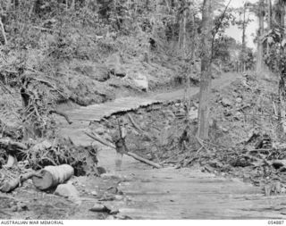 BULLDOG-WAU ROAD, NEW GUINEA, 1943-07-12. CORDUROYED SECTION OF ROAD AND BRIDGE AT THE 14 1/2 MILE POINT