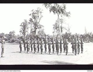 RABAUL, NEW BRITAIN, 1945-12-17. LIEUTENANT O. H. BATCHELOR, AUSTRALIAN ARMY EDUCATION SERVICE INSTRUCTING A JUNIOR NON-COMMISSIONED OFFICERS' CLASS OF 1ST NEW GUINEA INFANTRY BATTALION IN RIFLE ..