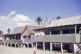 Guam, girl in front of stilt homes