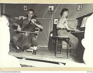 KOITAKI, PORT MORESBY AREA, PAPUA, NEW GUINEA. 1944-03-26. QX24600 LIEUTENANT COLONEL J. H. THORP, COMMANDING OFFICER, 113TH CONVALESCENT DEPOT (LEFT), ON THE STAGE OF THE MUSIC HUT ACCOMPANYING ..