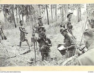 1943-10-08. NEW GUINEA. MARKHAM VALLEY ADVANCE. ON THE ROAD TO MARAWASA AUSTRALIANS PASS A FORWARD WIRELESS SPOTTER. (NEGATIVE BY G. SHORT)