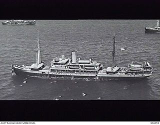 AERIAL PORT SIDE VIEW OF THE DUTCH TRANSPORT VAN SWOLL AT ANCHOR WITH TWO OTHER MERCHANT VESSELS. SHE WAS ONE OF THE VESSELS WHICH CARRIED AUSTRALIAN TROOPS BROUGHT TO RATAI BAY, JAVA, BY THE LINER ..