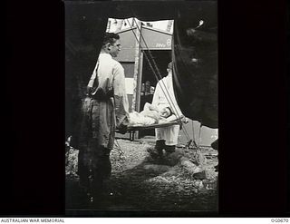 NADZAB, NEW GUINEA. C. 1944-02. AT NO. 24 MEDICAL CLEARING STATION RAAF LEADING AIRCRAFTMAN (LAC) J. C. KAVANAGH, HURLSTONE PARK, NSW, WHO WAS ACCIDENTALLY WOUNDED IN THE LEG BY MACHINE GUN, IS ..